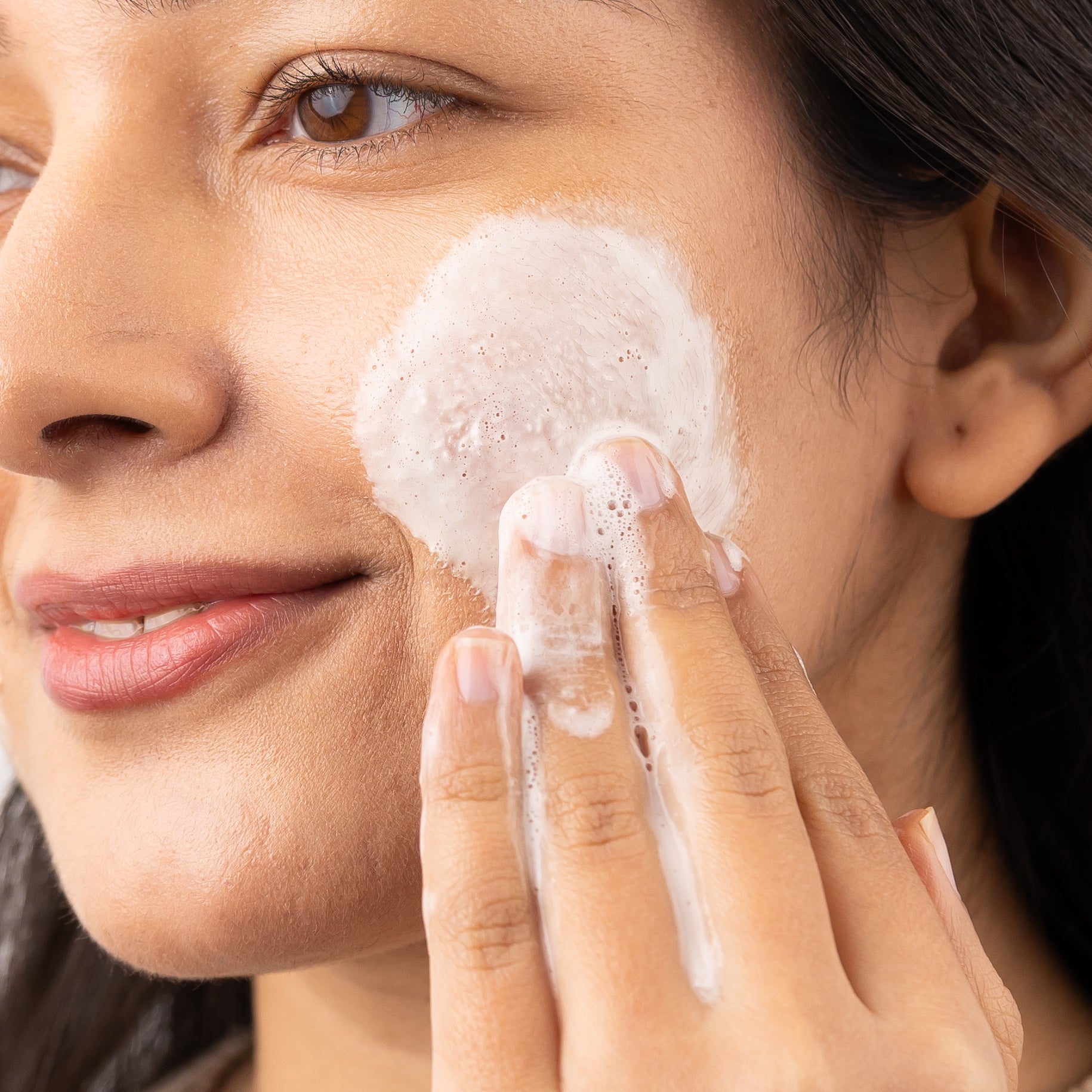  Woman cleansing her face with face wash using facial scrub